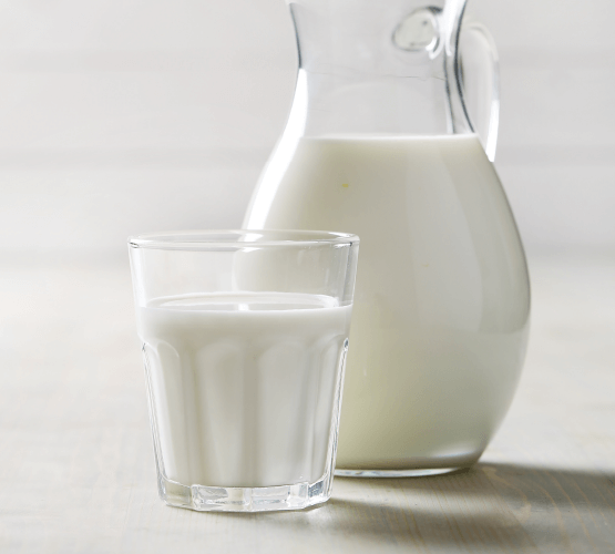 Glas mit Milch neben einer Karaffe