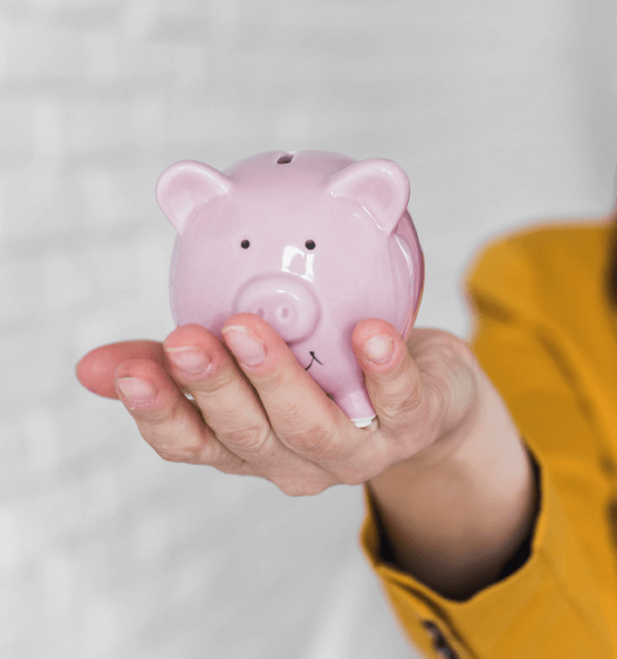 Rosa Sparschwein wird in einer Hand gehalten