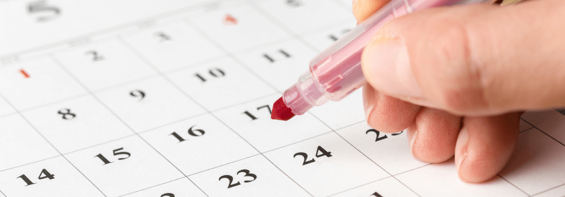 Hand markiert einen Termin in einem Kalender